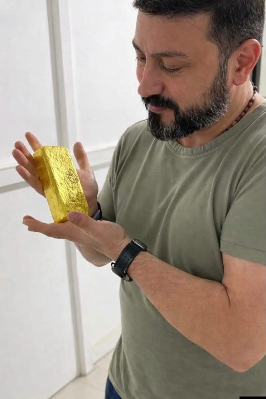 Gold dealer inspecting a gold bar
